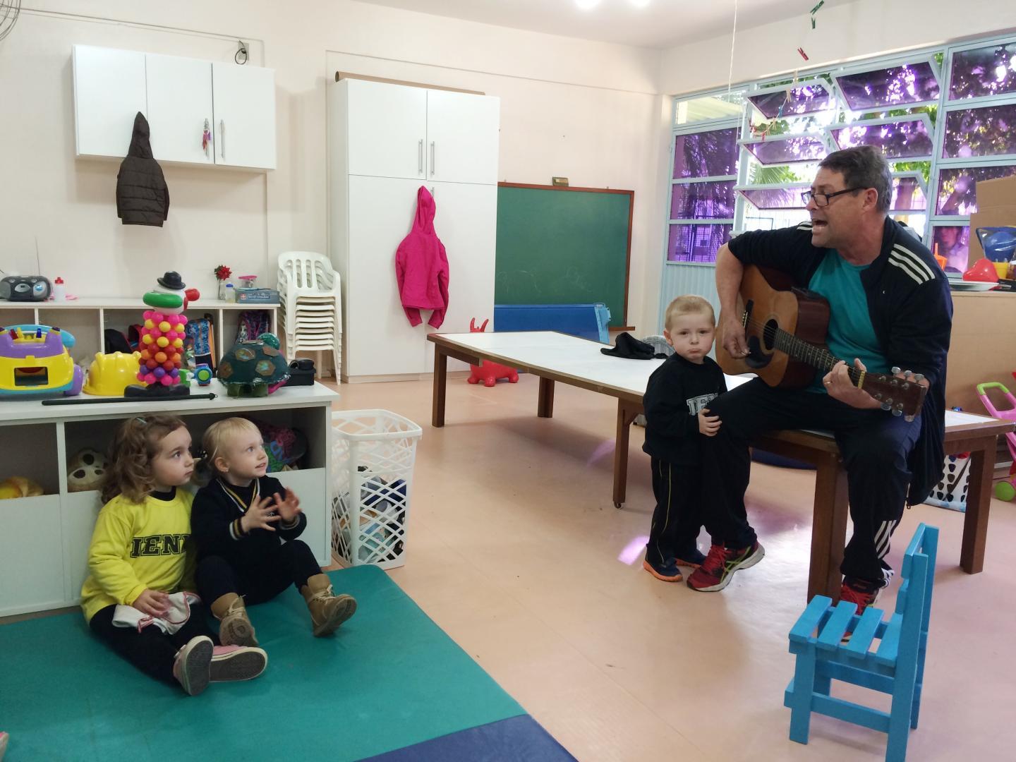 Pai de aluno anima aula do Nível 2 tocando músicas no violão