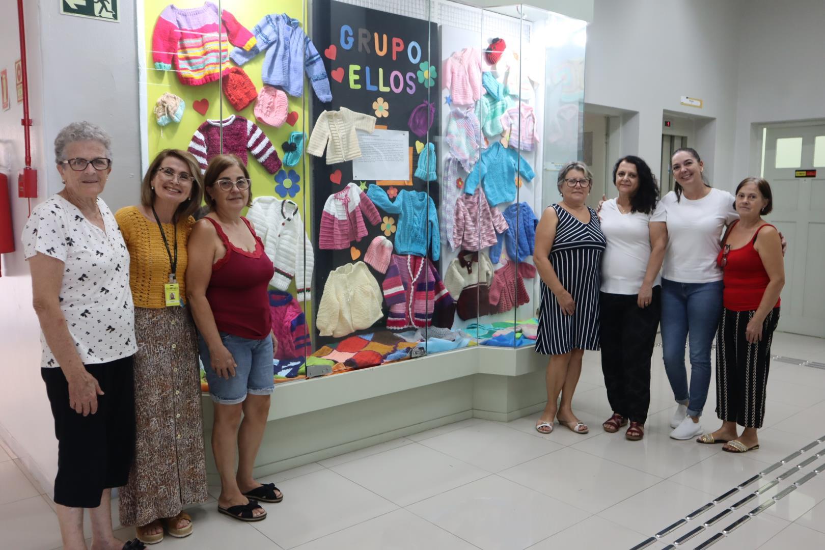 Peças de tricô produzidas pelas mulheres voluntárias do Grupo ELLOS são expostas em vitrine na IENH